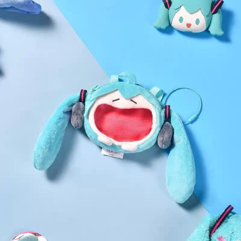 Hatsune Miku plush coin pouch with open-mouth design and twin tails on blue background.