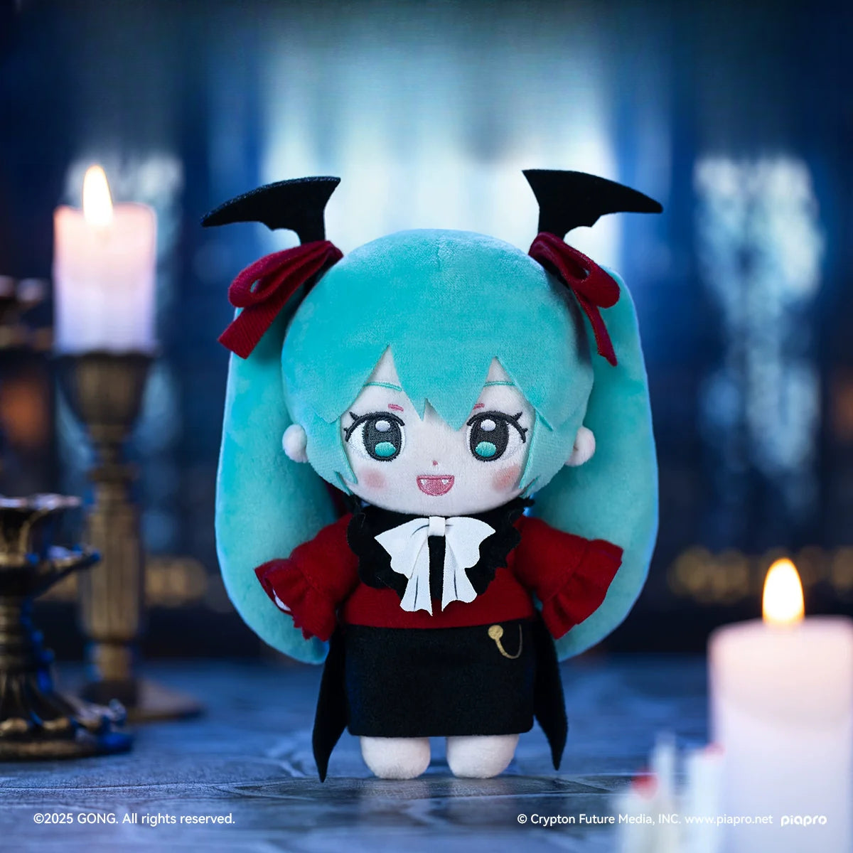 Vampire-themed Hatsune Miku plush doll with bat wings and red-black outfit in candlelit scene.