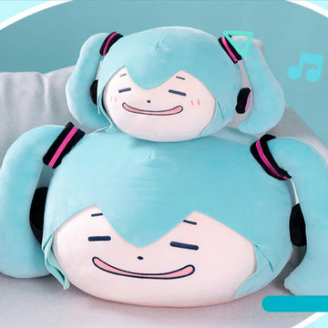 Two meme-style Hatsune Miku plush pillows stacked together, both with funny smiling faces