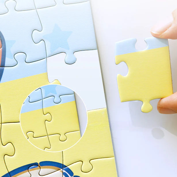 Close-up of a hand placing a yellow puzzle piece into place, with zoomed-in alignment detail.