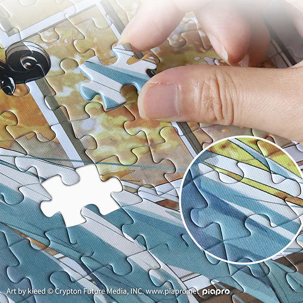 Close-up of a hand placing a piece into a Hatsune Miku jigsaw puzzle