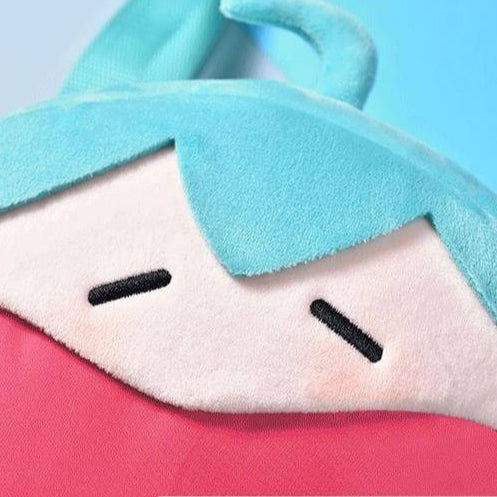 Close-up of Hatsune Miku plush pouch showing sleepy face and red interior fabric.