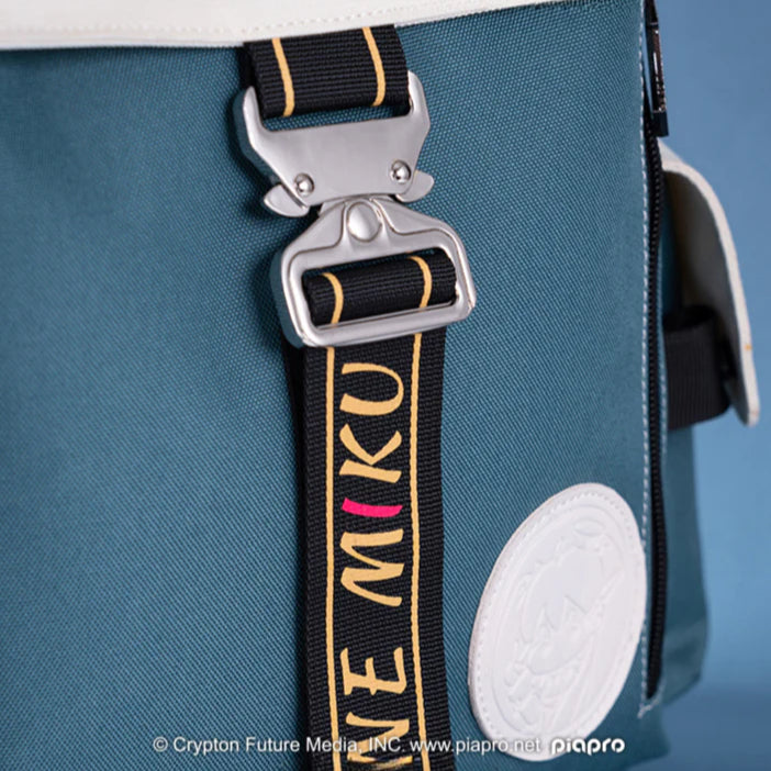 Close-up of a Hatsune Miku bag buckle with a strap that reads “MIKU” in yellow and pink
