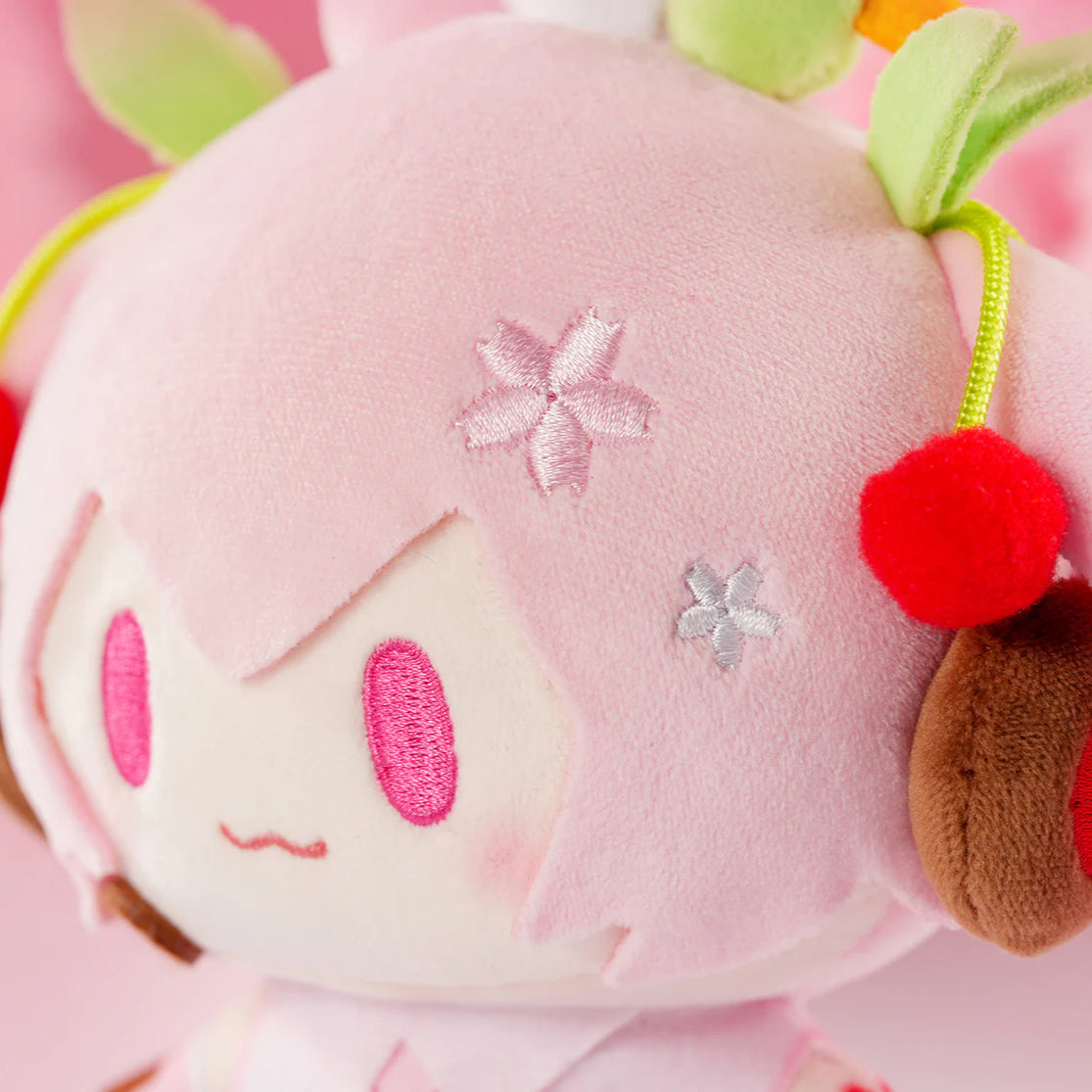 Close-up of Sakura Miku plush with embroidered cherry blossoms and red cherry hair accessories