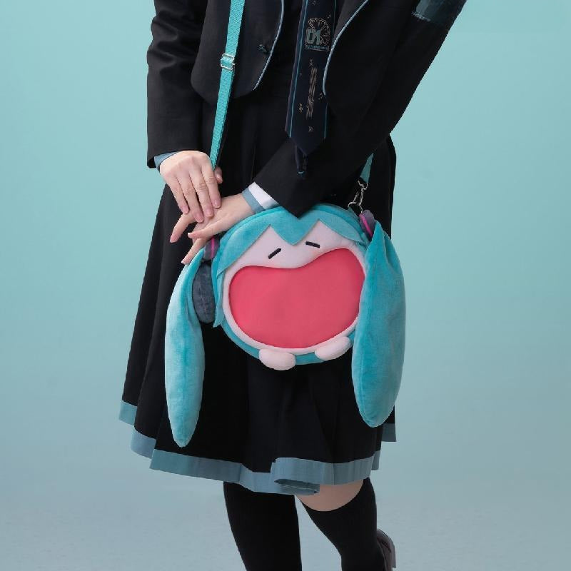Model in Miku uniform wearing Hatsune Miku open-mouth plush bag with red interior.