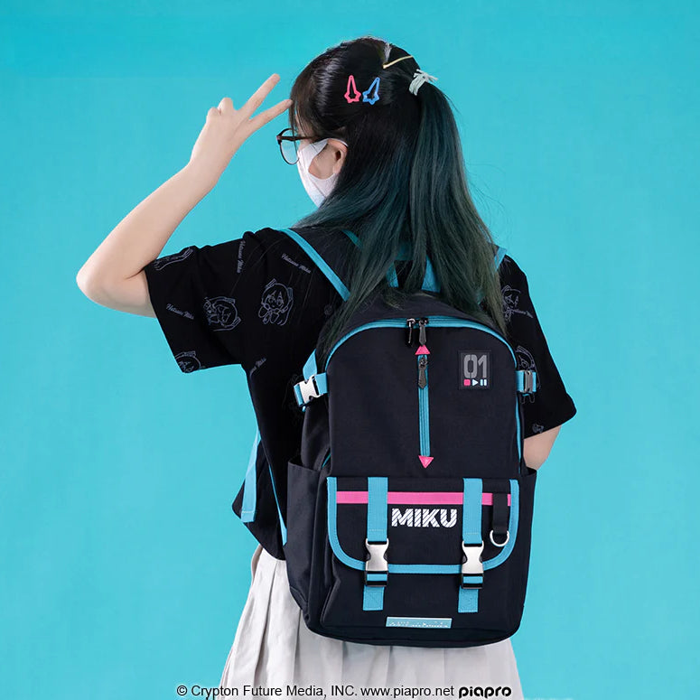 Girl wearing a black Hatsune Miku backpack with teal and pink accents and a bold “MIKU” logo